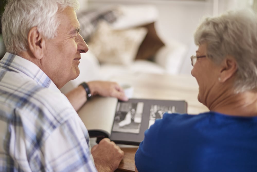 Smiling senior couple looking at photo album together